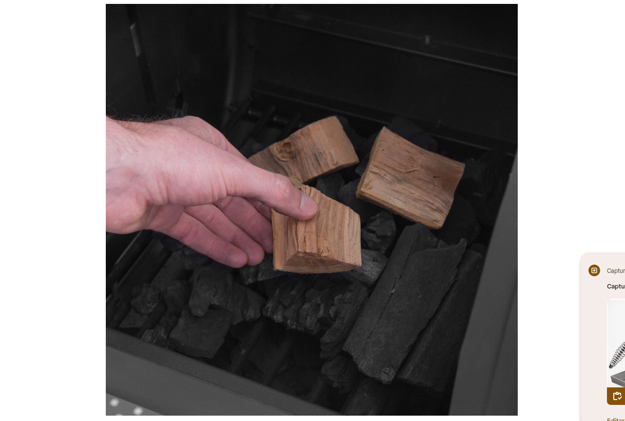 Añadiendo bloques de madera de nogal a la caja de fuego lateral del ahumador Regal Offset 500 para sabor ahumado.