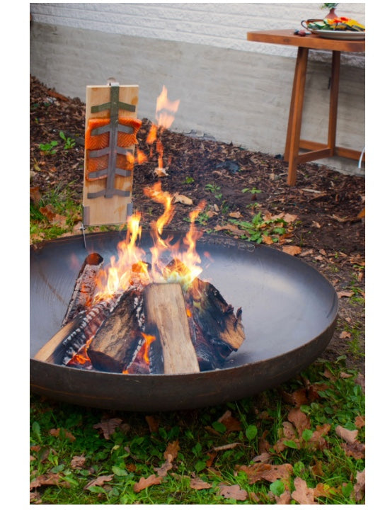 Cocinando salmón al fuego con la tabla de ahumar BonFeu en una chimenea de jardín