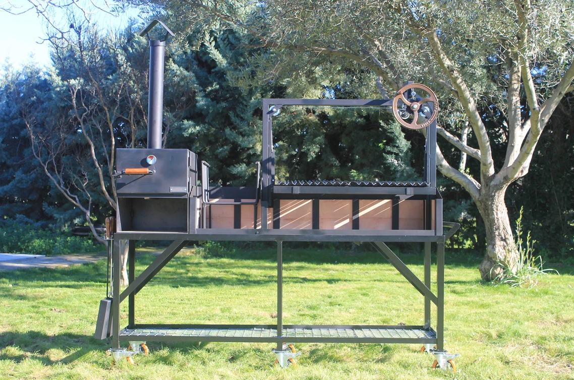 Barbacoa argentina Kandinsky de Wagner Grills con horno de leña integrado, sistema de elevación por manivela y estructura profesional de acero.