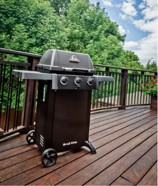 Barbacoa Broil King Gem 310 Shadow instalada en una terraza de madera, mostrando su tamaño ideal para espacios pequeños