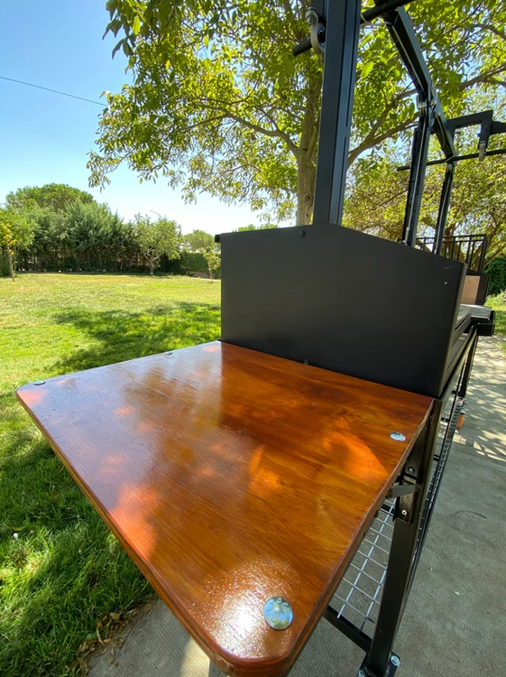 Detalle de la robusta mesa lateral de madera de la barbacoa Sorolla, ideal para apoyo de utensilios y preparación de carnes