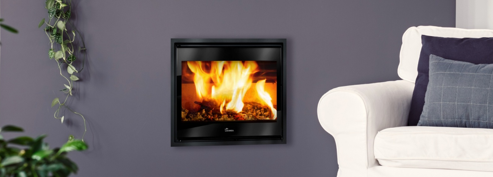 Chimenea de leña encastrable Lacunza Adour instalada en salón moderno con sofá blanco