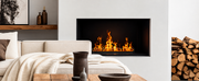 Quemador de vapor de agua Planika Cool Flame integrado en una pared minimalista de salón, ofreciendo un fuego seguro y decorativo