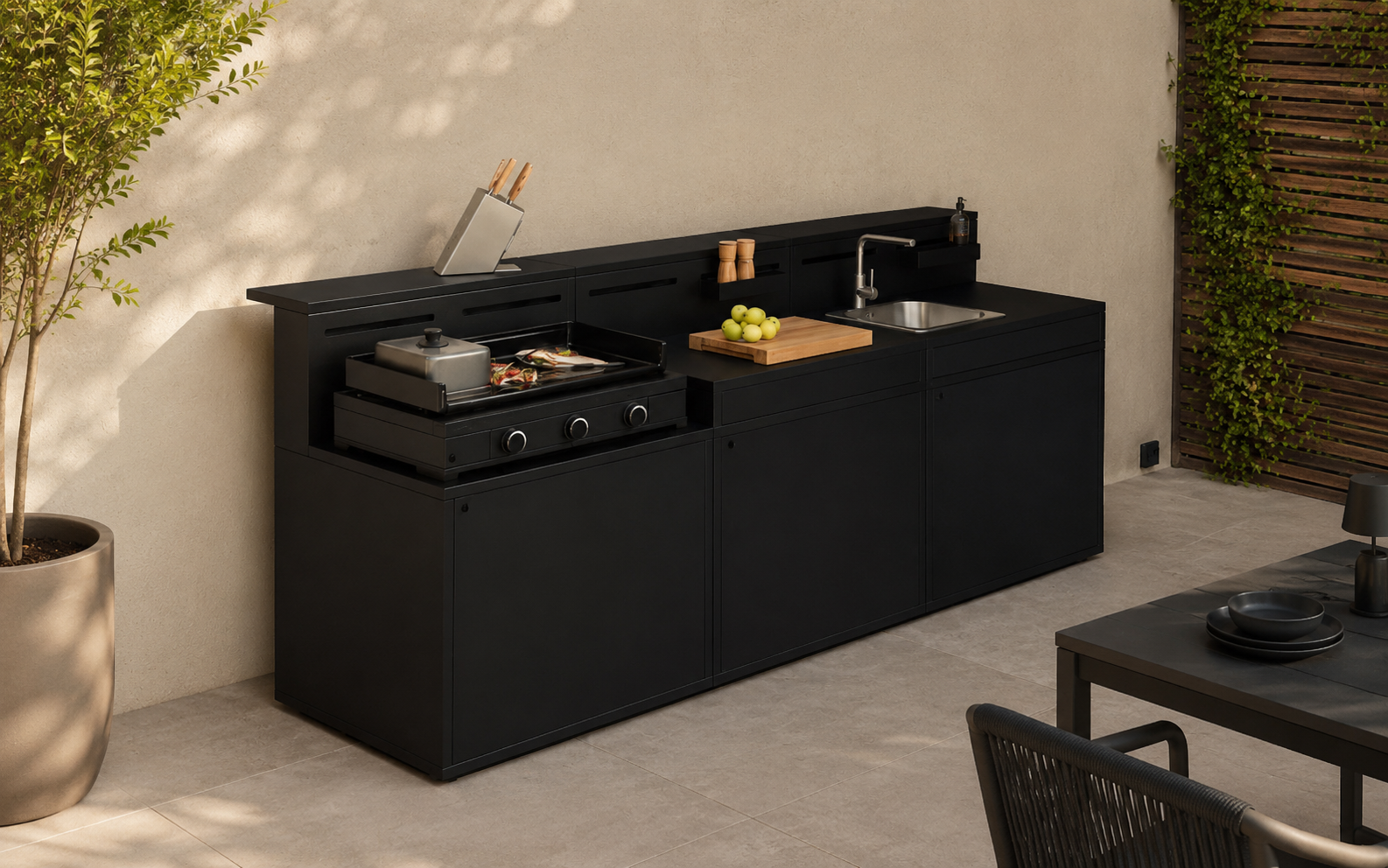 Cocina de exterior modular WMF Profi instalada en terraza moderna, equipada con plancha de gas, fregadero y zona de preparación.