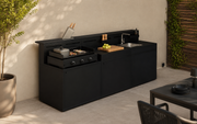 Cocina de exterior modular WMF Profi instalada en terraza moderna, equipada con plancha de gas, fregadero y zona de preparación.