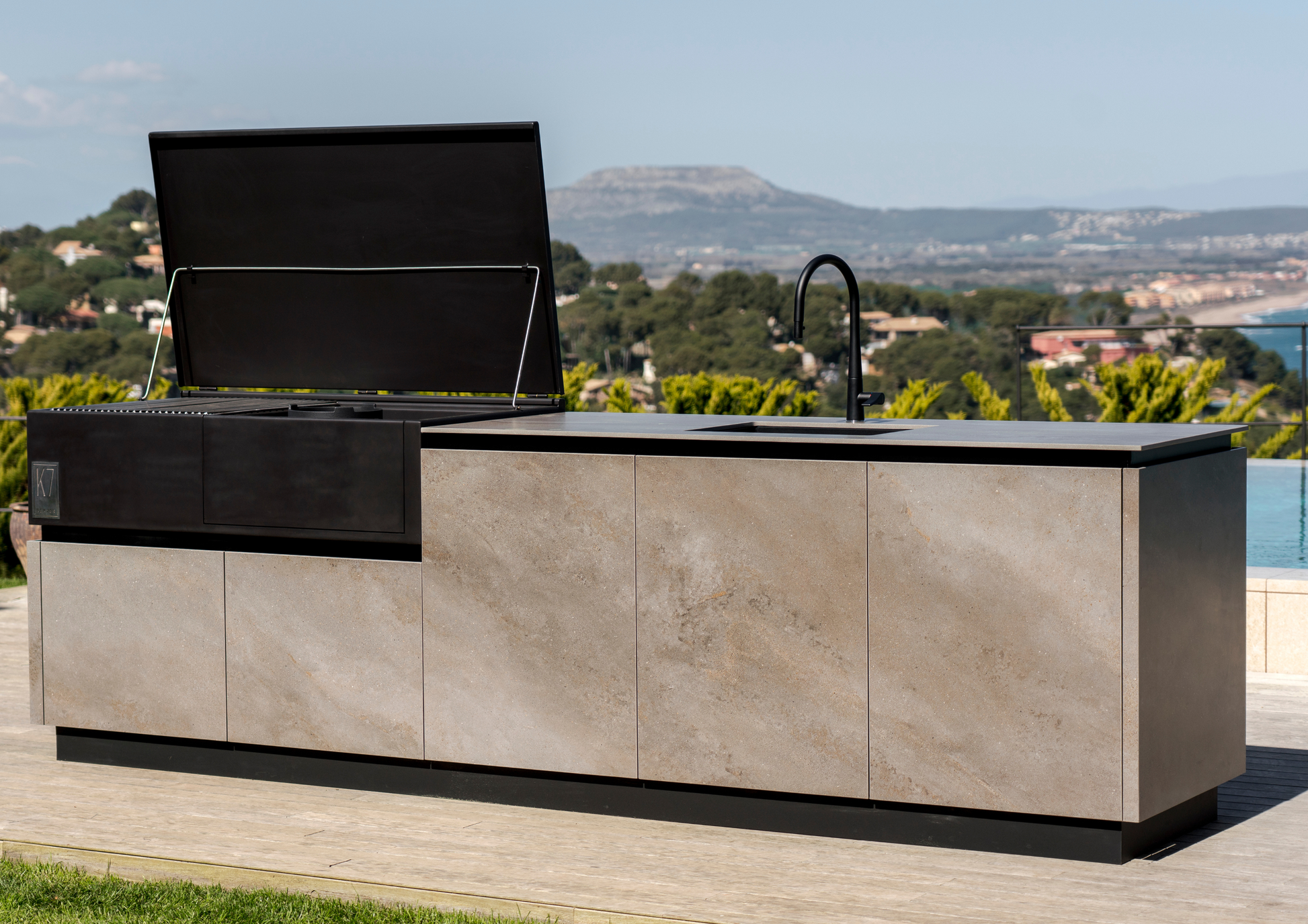 Configuración de cocina modular K7 de Rekker instalada en una terraza moderna con zona de barbacoa.
