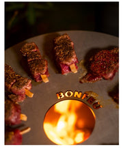 Chuletas de ternera cocinándose sobre la BonPlancha circular para el modelo BonVes