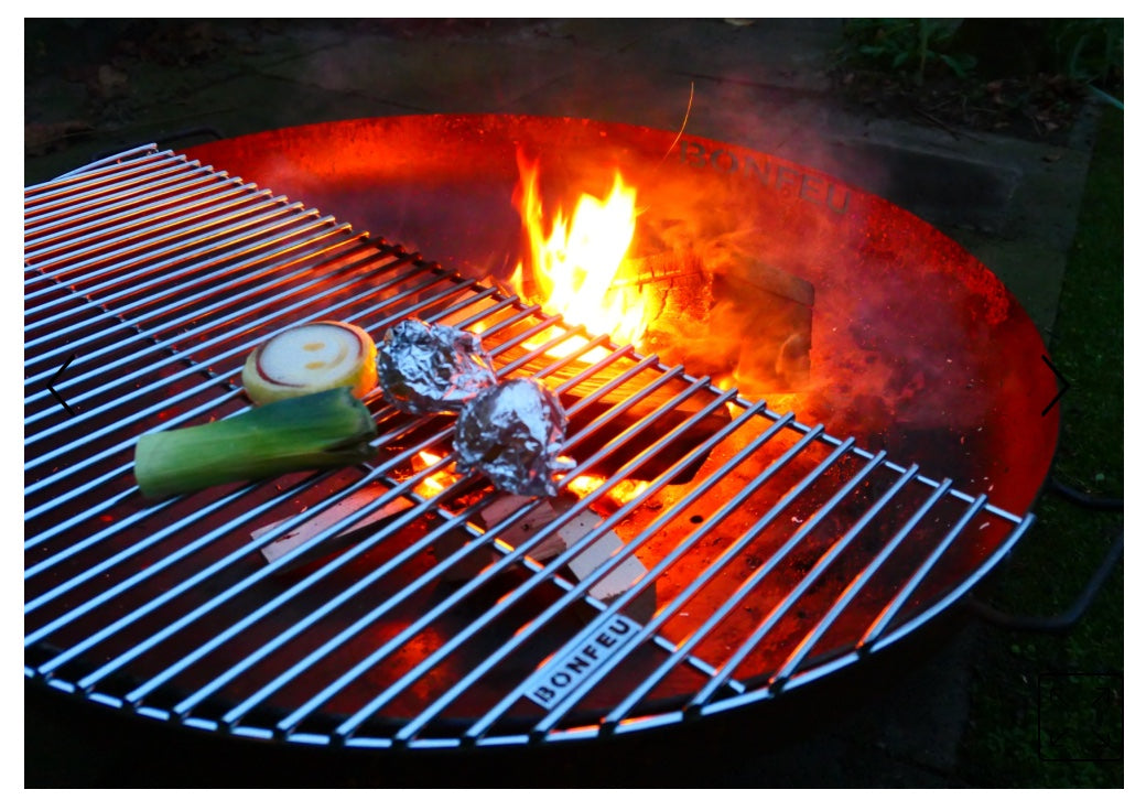 Barbacoa exterior usando el medio grill de BonFeu con fuego de leña real
