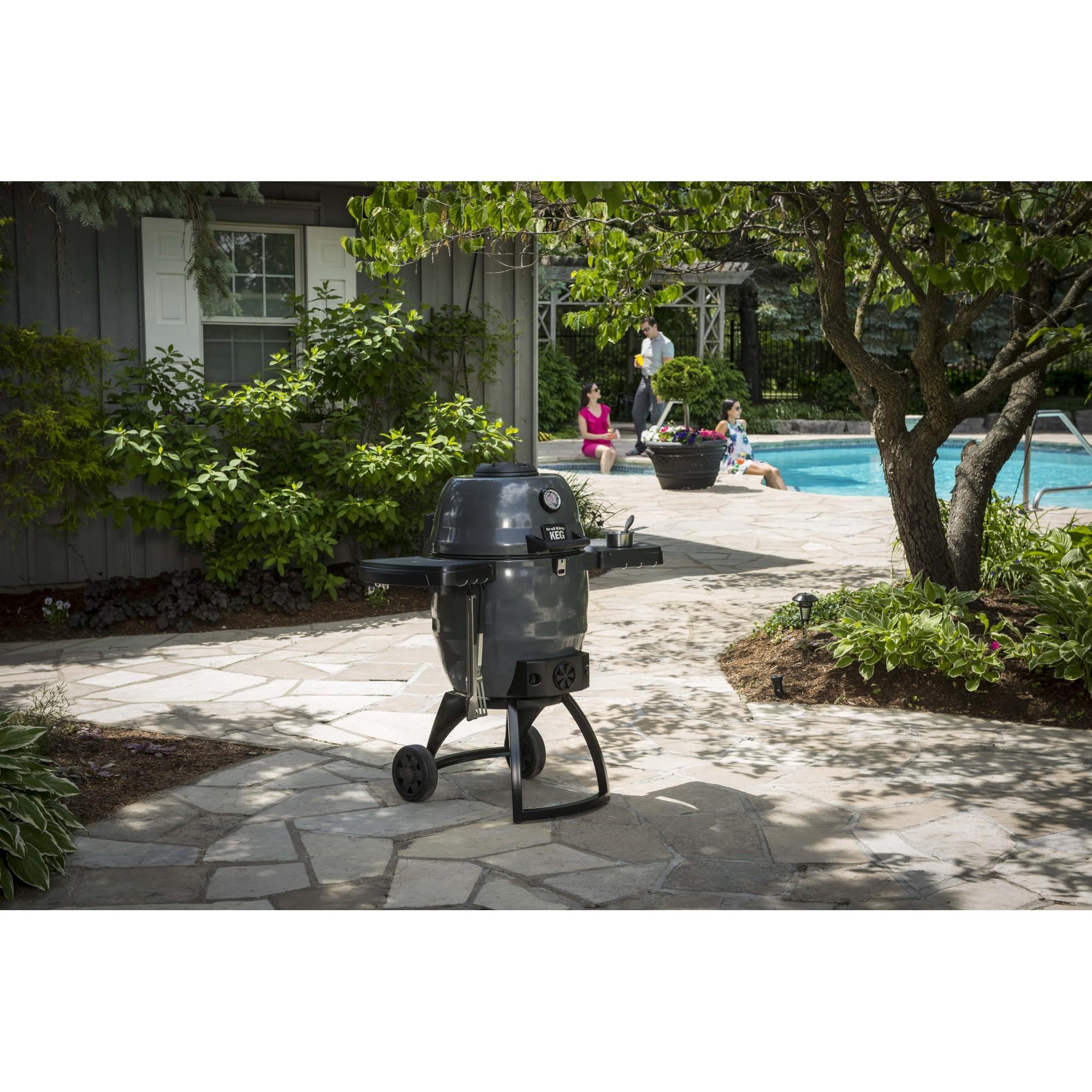 Barbacoa de carbón profesional Broil King Keg 5000 instalada en un patio exterior.