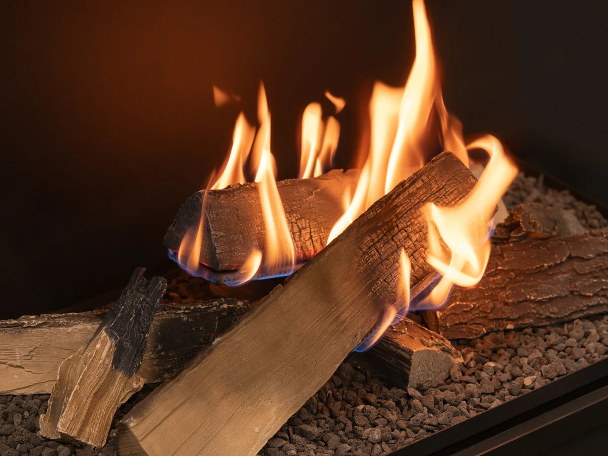 Primer plano del efecto de fuego envolvente sobre los leños decorativos del modelo Flogs 990.