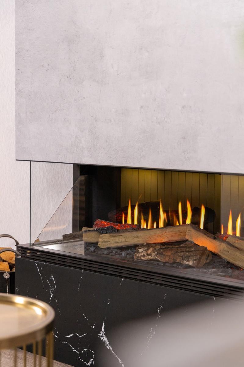 Chimenea Holo Vista instalada en revestimiento de mármol blanco bajo televisión