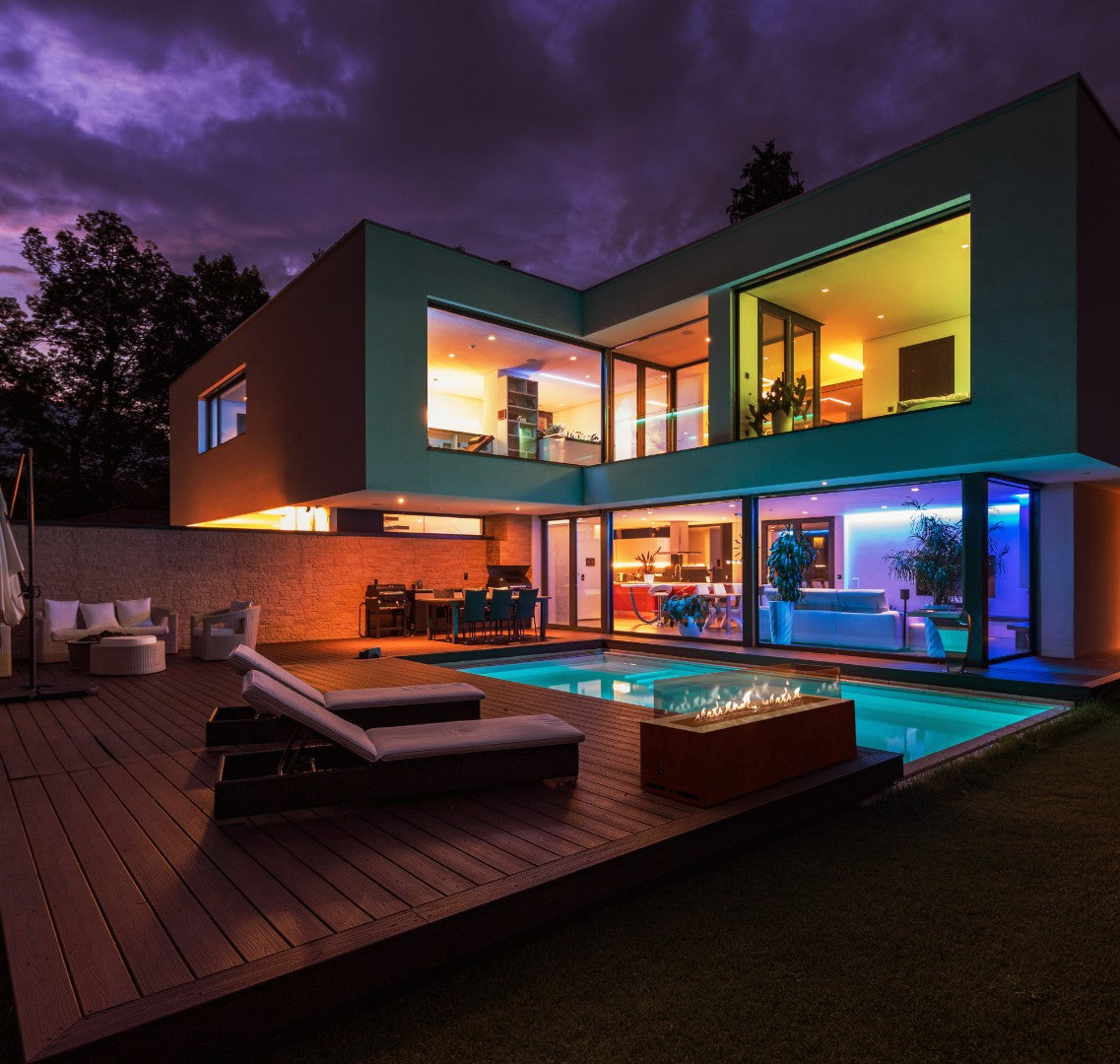 Terraza de lujo con piscina y chimenea de gas Planika Galaxy encendida al atardecer