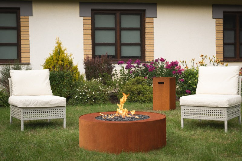 Fire pit automático Planika Galio Star instalado en un jardín con césped y butacas
