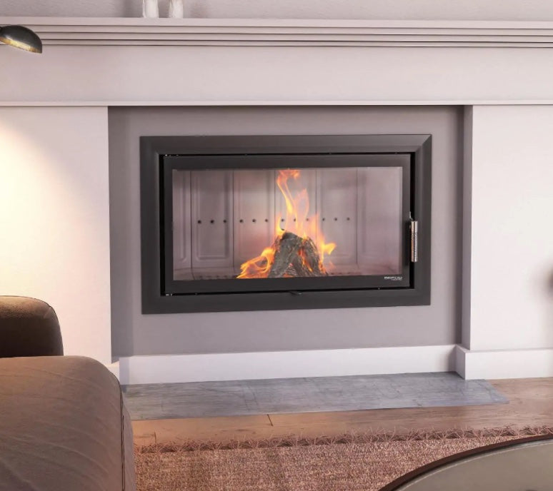 Hogar de leña Defro Home Intra LA integrado en una chimenea minimalista blanca con sistema de apertura vertical.