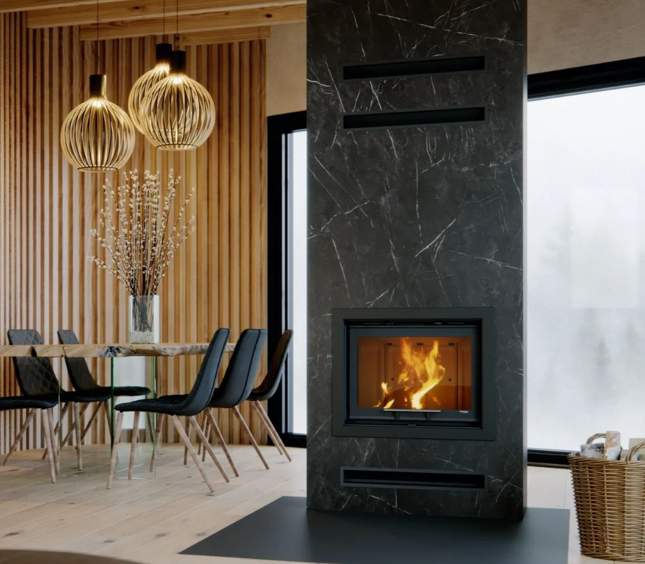 Chimenea de leña Defro Home Intra S G con puerta elevable integrada en una columna de mármol negro en un comedor de diseño.