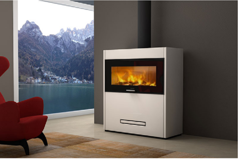 Estufa insertable Piazzetta Lugano BL en acabado blanco instalada frente a un ventanal con vistas al lago y montaña