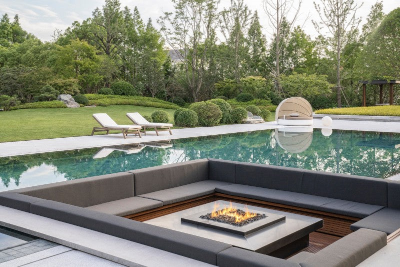 Chimenea de exterior Planika Galio H instalada en zona de relax junto a una piscina