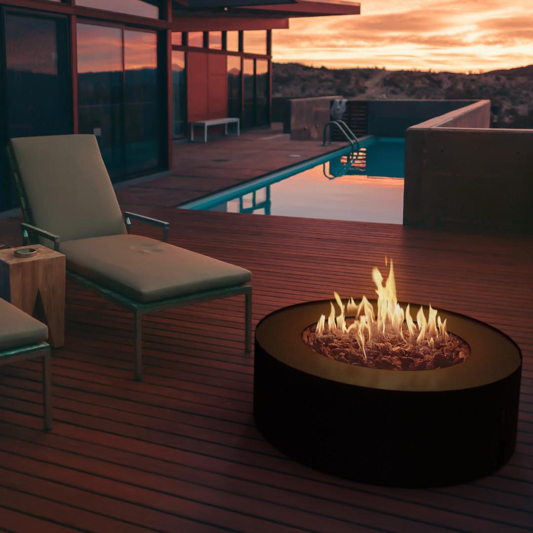 Zona chill out con piscina y chimenea circular Planika Galio Star negra