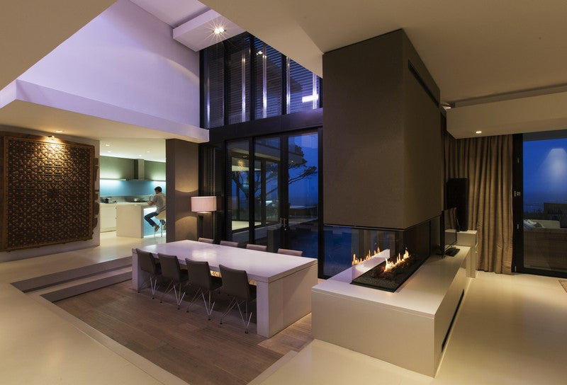 Salón moderno con chimenea Planika Panorama 1200 integrada en isla divisoria