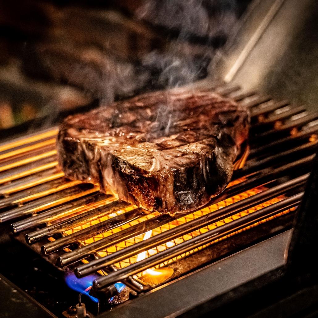 Chuletón de carne sellándose a alta temperatura en el quemador lateral infrarrojo de la Baron S 490 IR