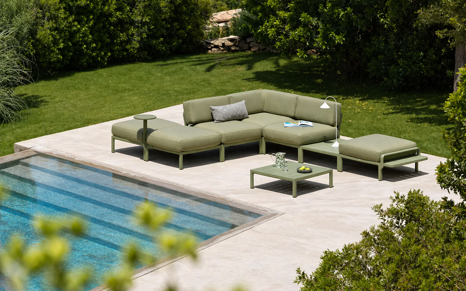 Sofá modular de exterior Nardi Maximo 5 en color verde cactus configurado en esquina junto a una piscina